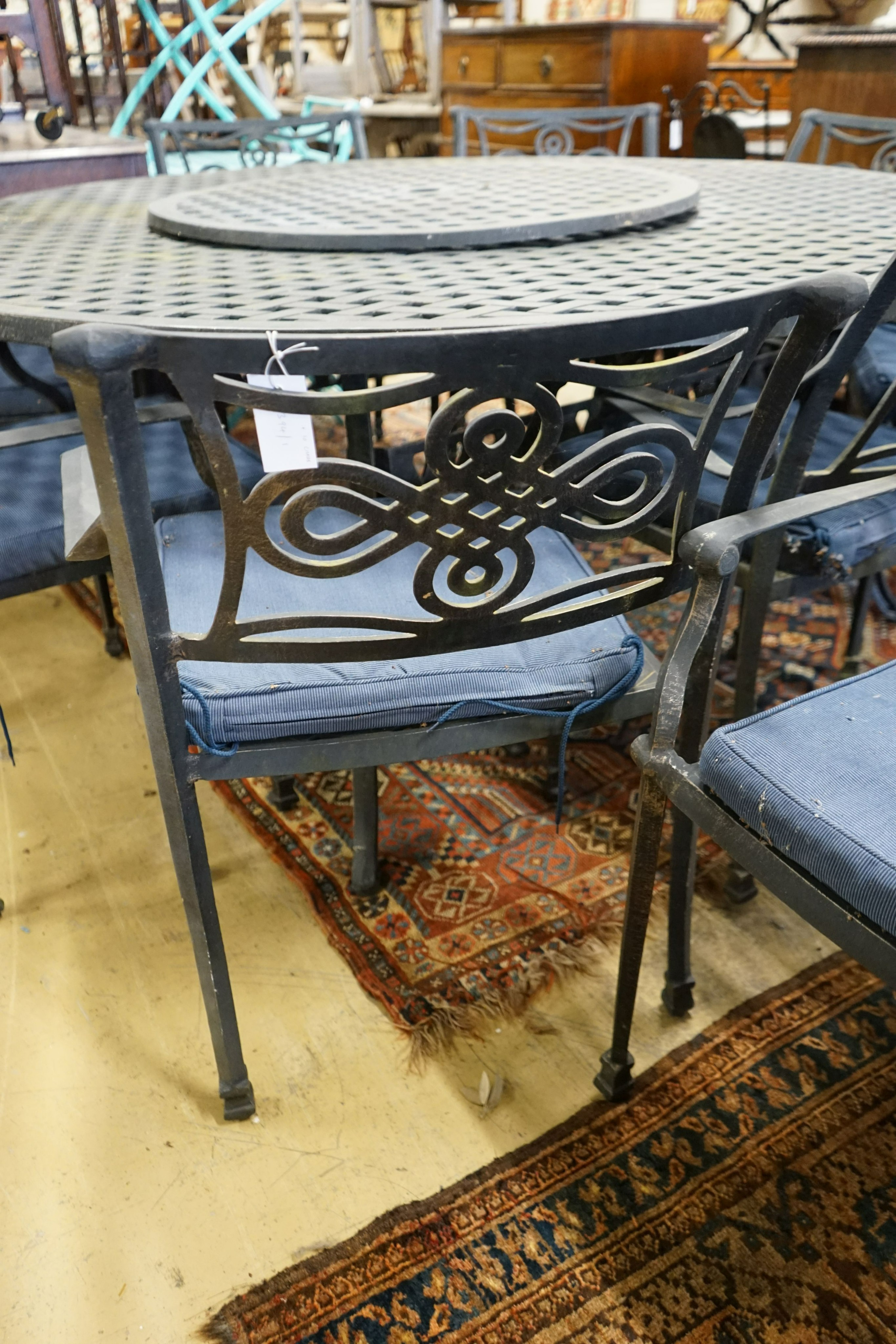 A circular painted aluminium garden table with 'lazy Susan', diameter 180cm, height 73cm together with ten aluminium elbow chairs with seat pads, (one base strut missing from table).